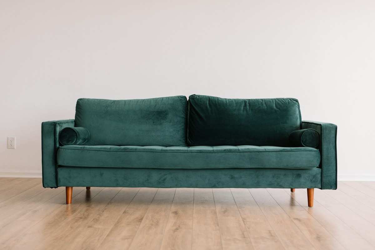 Forest green sofa with bolster cushions and tapered legs